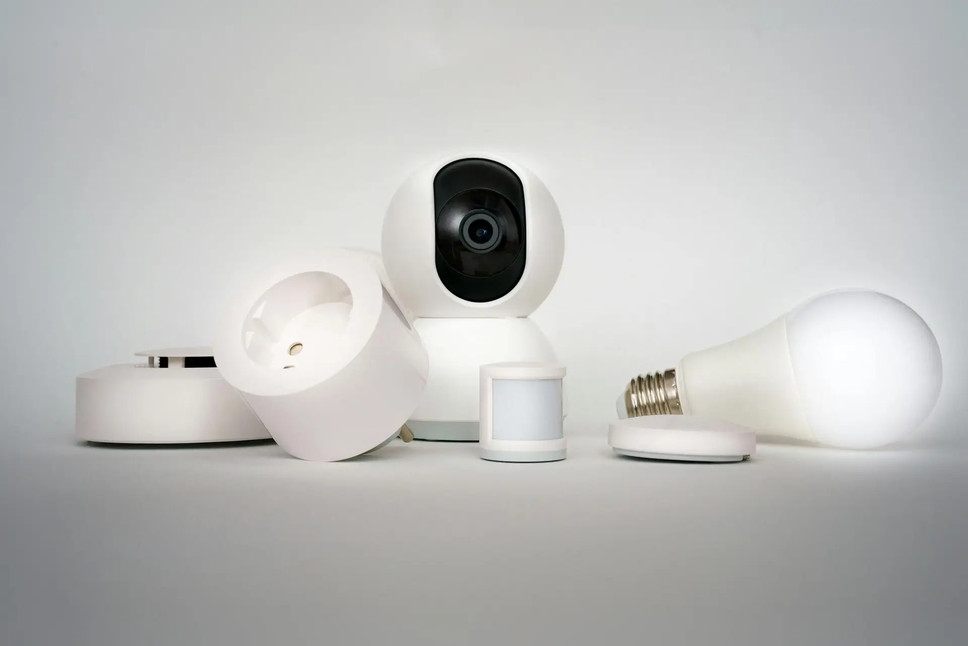 A range of smart home devices including CCTV camera and lightbulb in a minimalist setup.